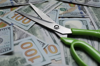 Photo of Dollar banknotes and scissors as background, closeup