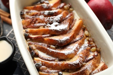 Photo of Freshly baked bread pudding in baking dish on table, closeup