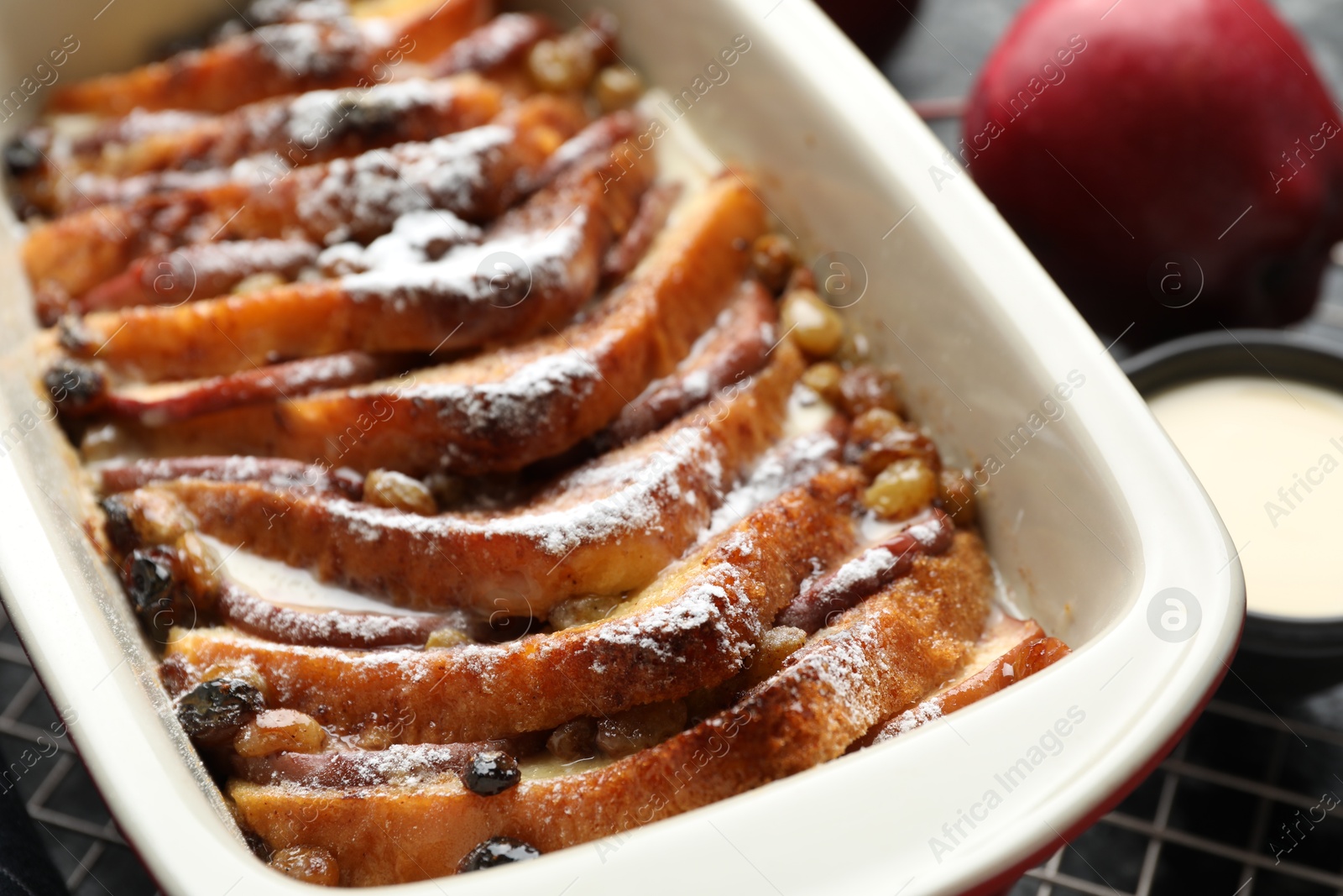 Photo of Freshly baked bread pudding in baking dish on table, closeup