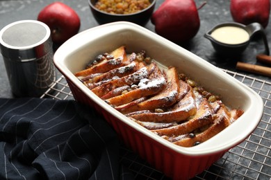 Photo of Freshly baked bread pudding in baking dish on grey table, closeup