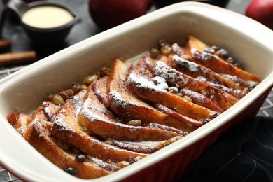 Photo of Freshly baked bread pudding in baking dish on table, closeup