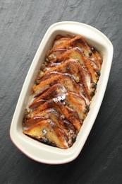 Photo of Freshly baked bread pudding in baking dish on grey textured table, top view