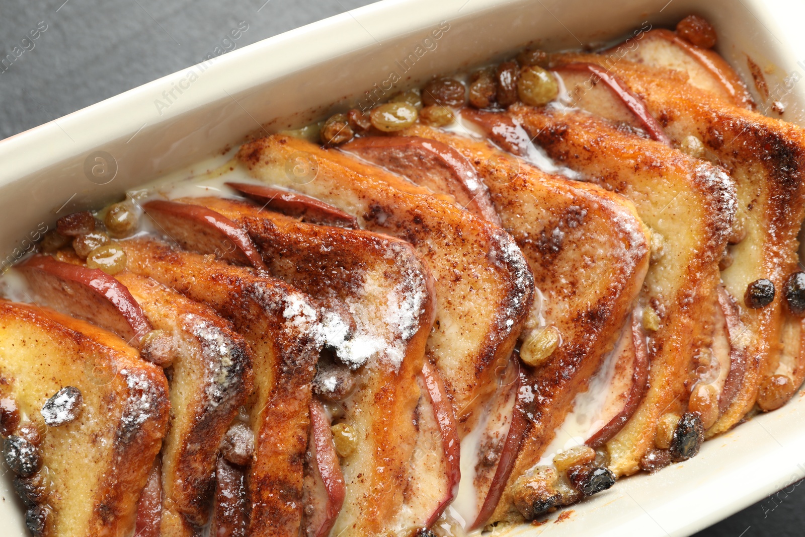 Photo of Freshly baked bread pudding in baking dish on grey table, top view