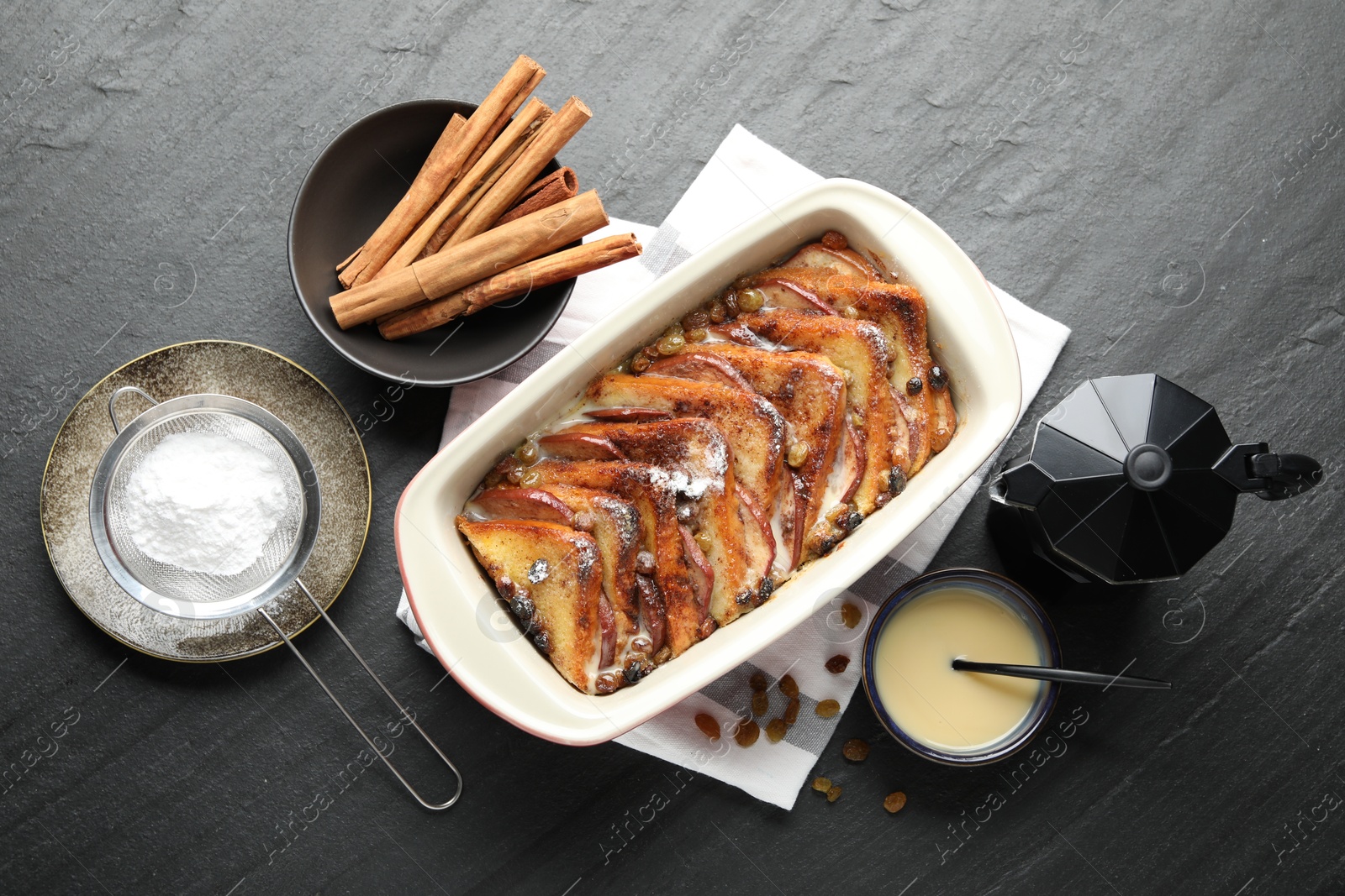 Photo of Flat lay composition with freshly baked bread pudding on dark textured table