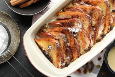 Photo of Flat lay composition with freshly baked bread pudding on dark table