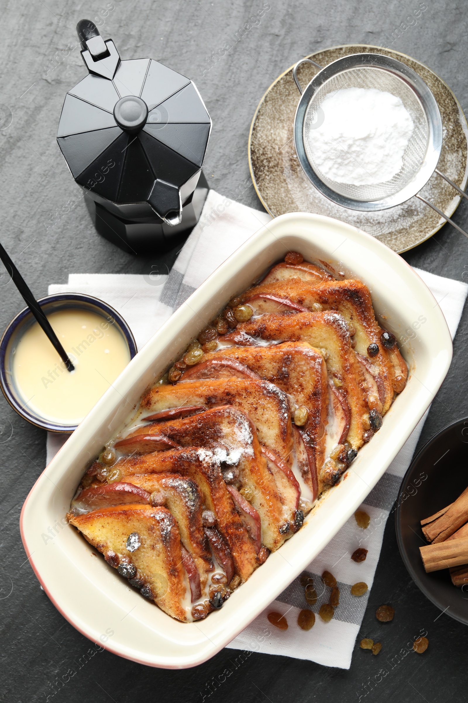 Photo of Flat lay composition with freshly baked bread pudding on dark textured table