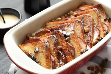 Photo of Freshly baked bread pudding in baking dish on table, closeup