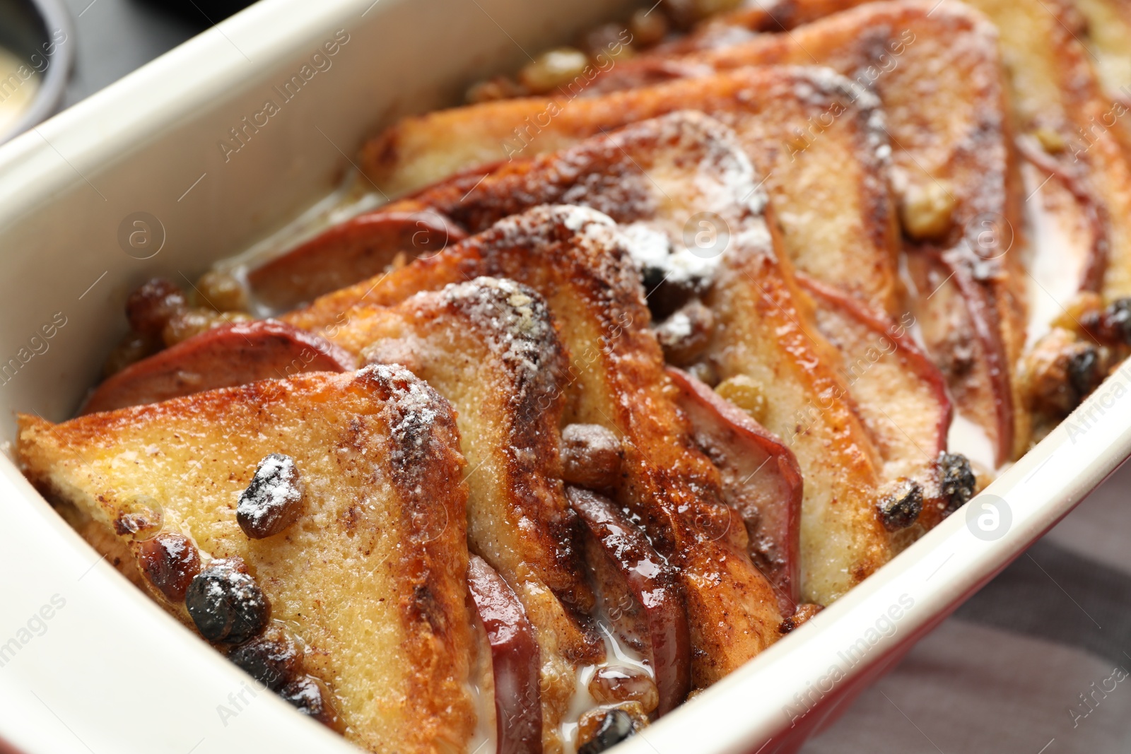 Photo of Freshly baked bread pudding in baking dish on table, closeup