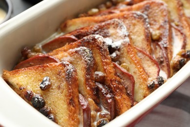 Photo of Freshly baked bread pudding in baking dish on table, closeup