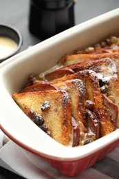 Photo of Freshly baked bread pudding in baking dish on table, closeup