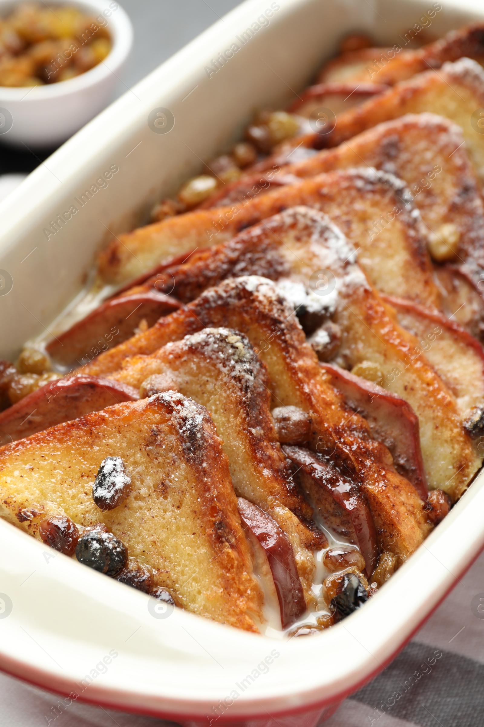 Photo of Freshly baked bread pudding in baking dish on table, closeup