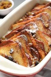 Photo of Freshly baked bread pudding in baking dish on table, closeup