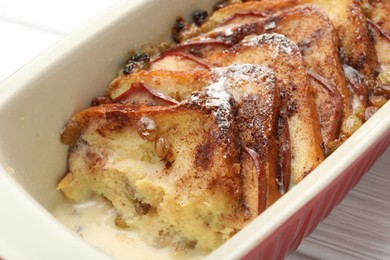 Photo of Freshly baked bread pudding in baking dish on white wooden table, closeup