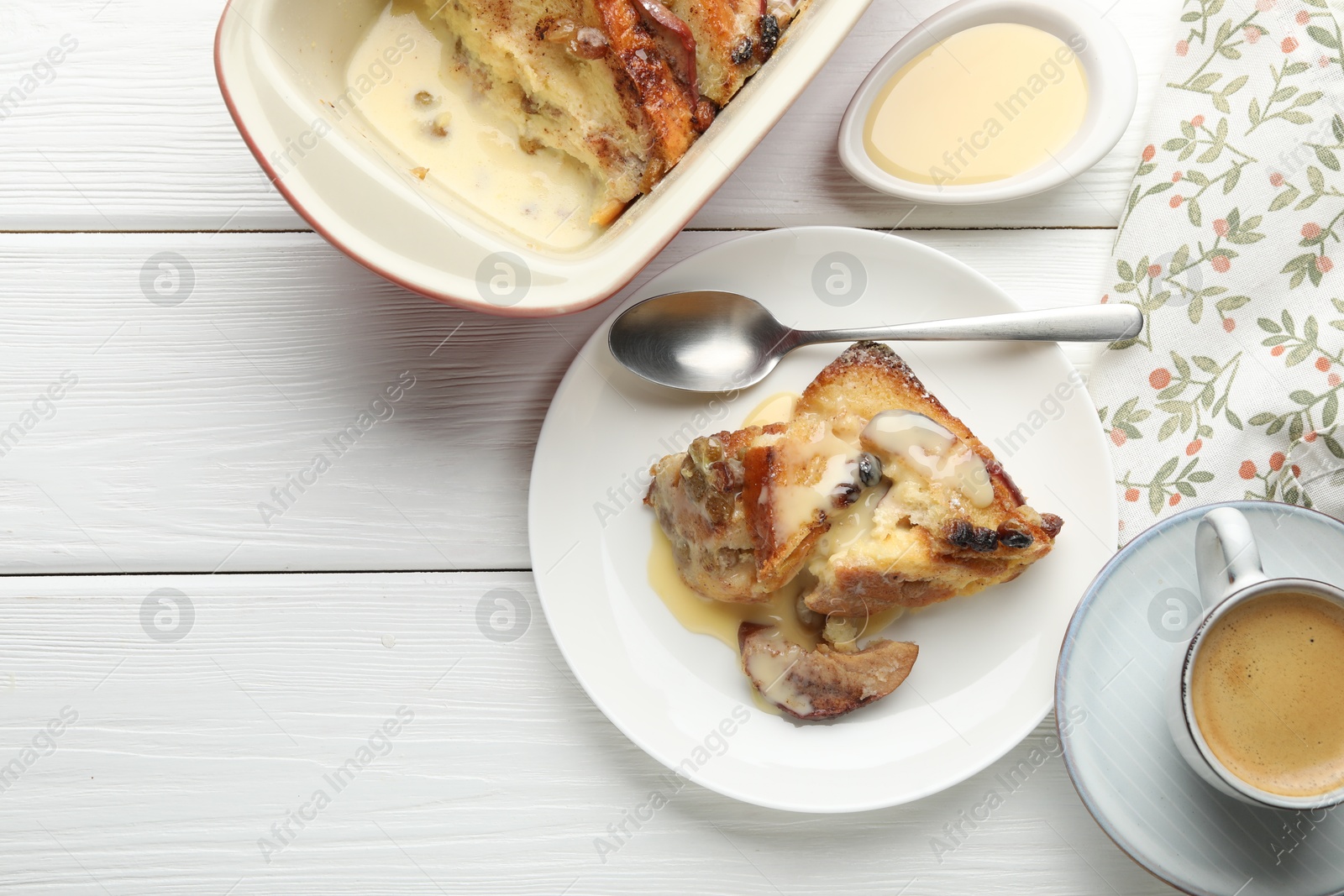 Photo of Freshly baked bread pudding and coffee on white wooden table, flat lay. Space for text