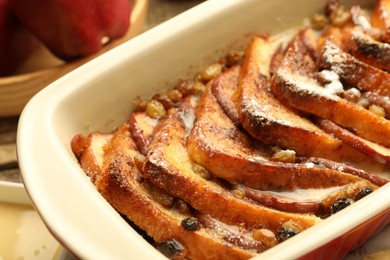 Photo of Freshly baked bread pudding in baking dish on table, closeup