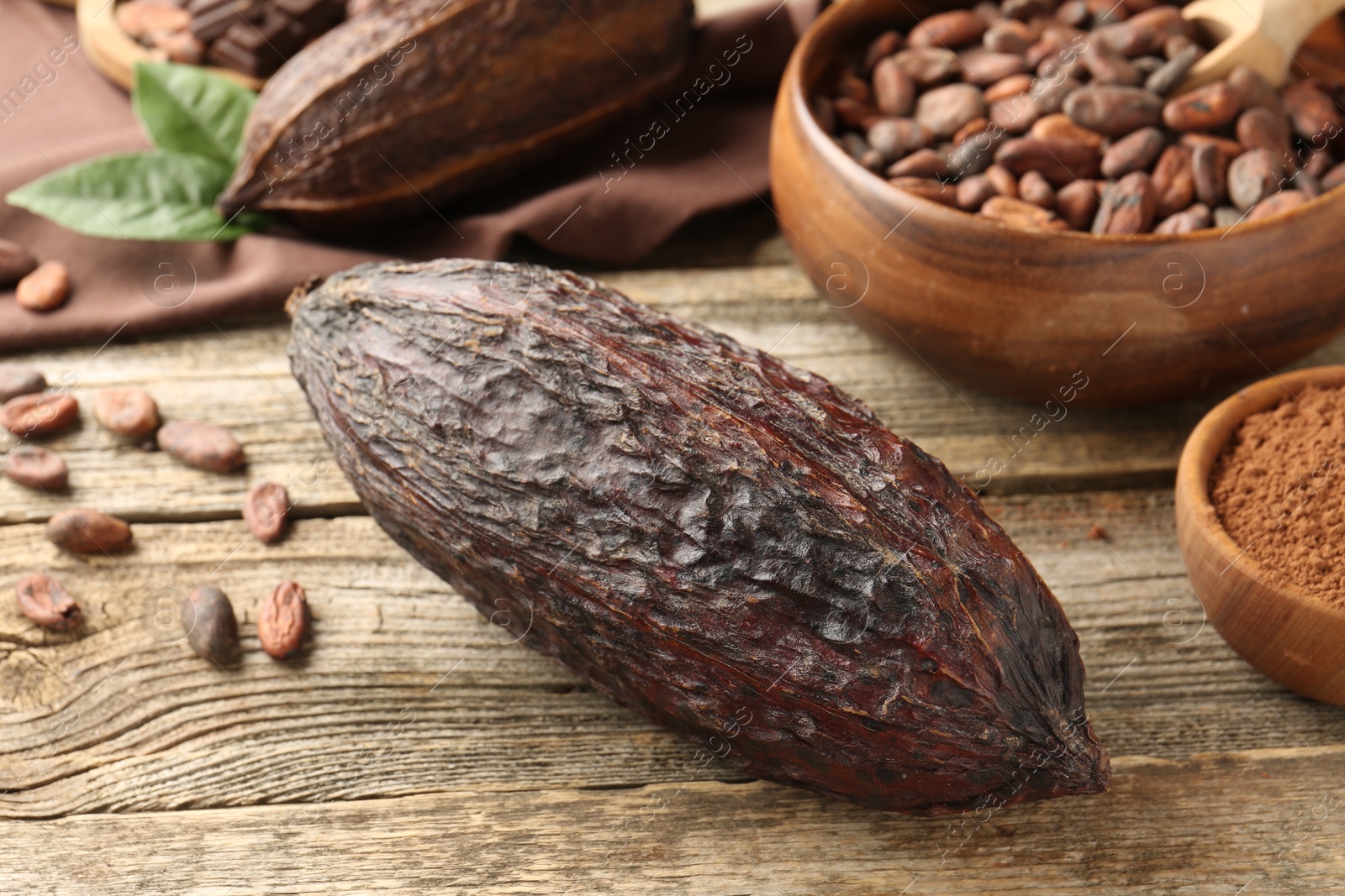 Photo of Cocoa pods and beans on wooden table, closeup