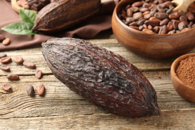 Photo of Cocoa pods and beans on wooden table, closeup