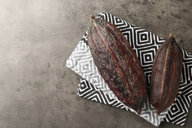 Photo of Cocoa pods on grey table, top view. Space for text