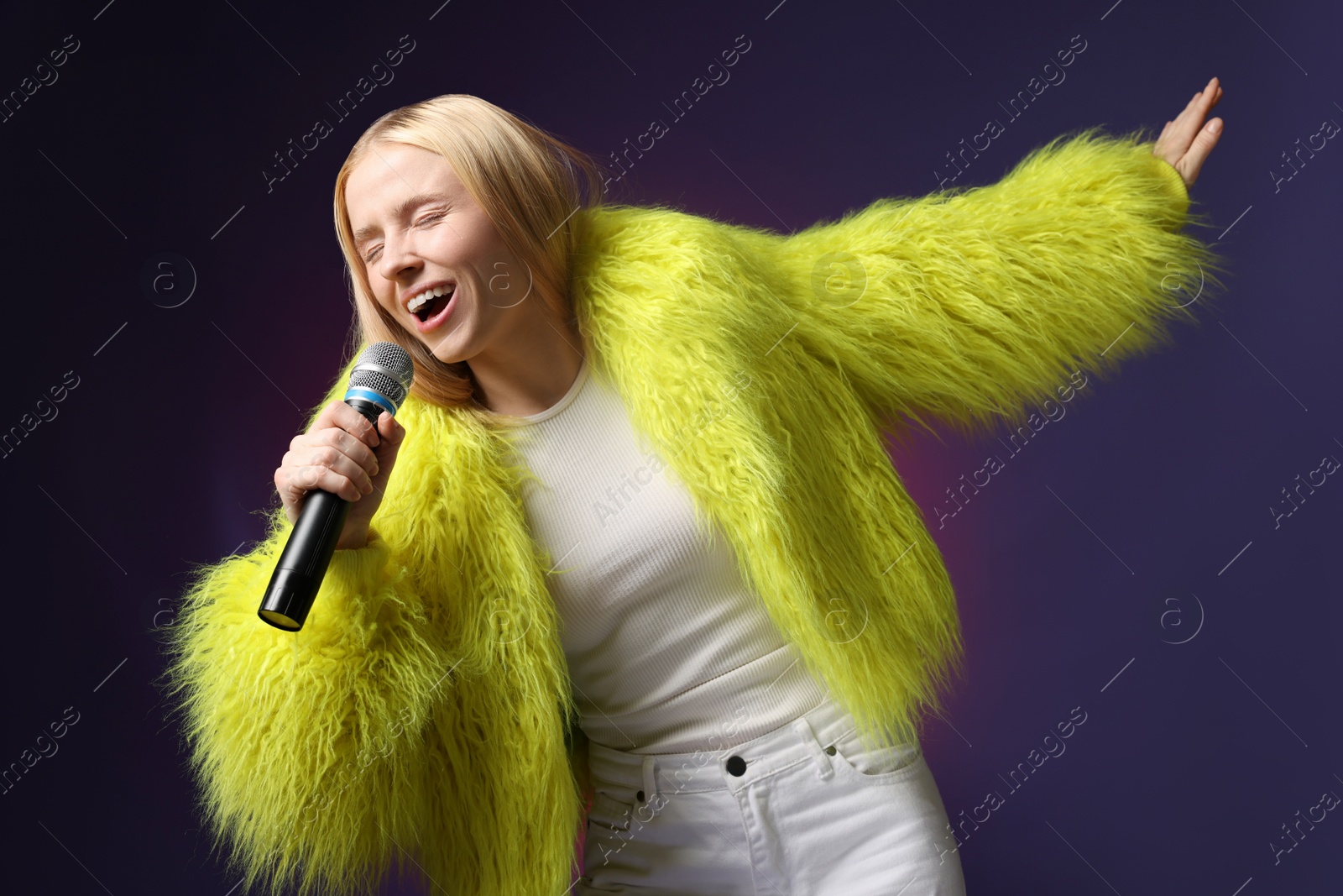 Photo of Talented singer in faux fur performing on dark background