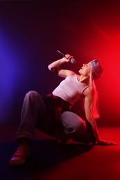 Talented singer performing on dark background with color lights