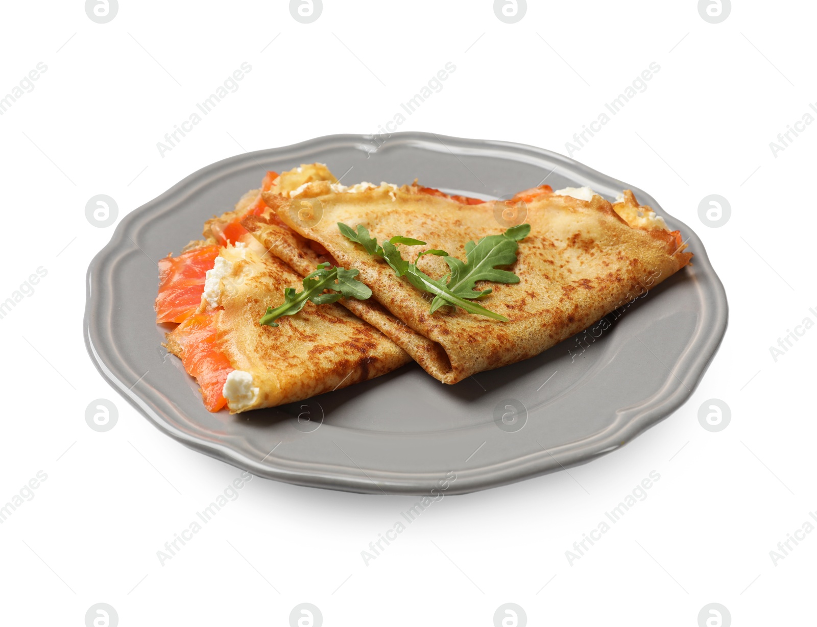 Photo of Delicious crepes with salmon, cream cheese and arugula isolated on white