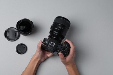 Photo of Photographer with professional camera on grey background, top view