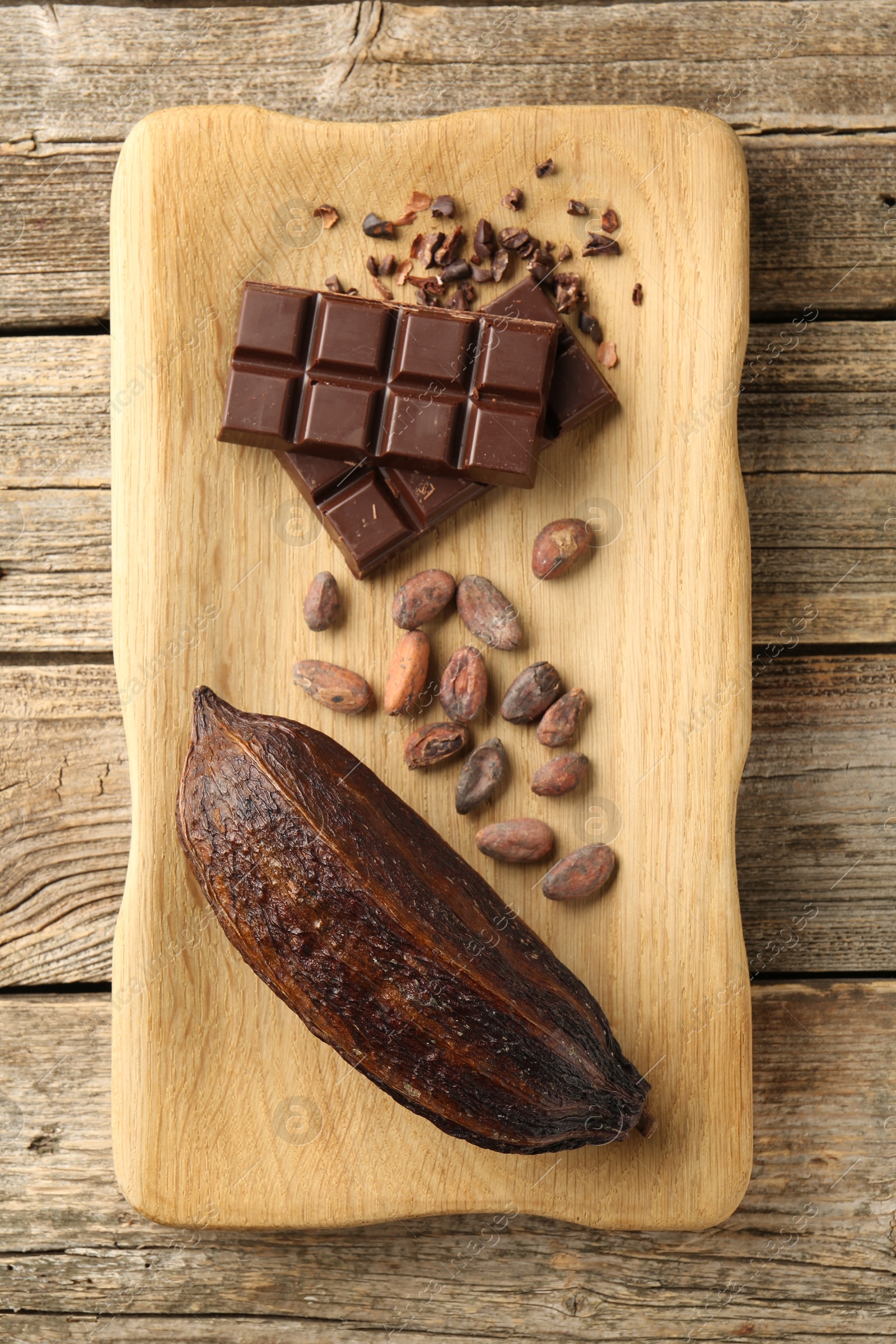 Cocoa pod, beans and chocolate on wooden table, top view Photo of Cocoa pod, beans and chocolate on wooden table, top view