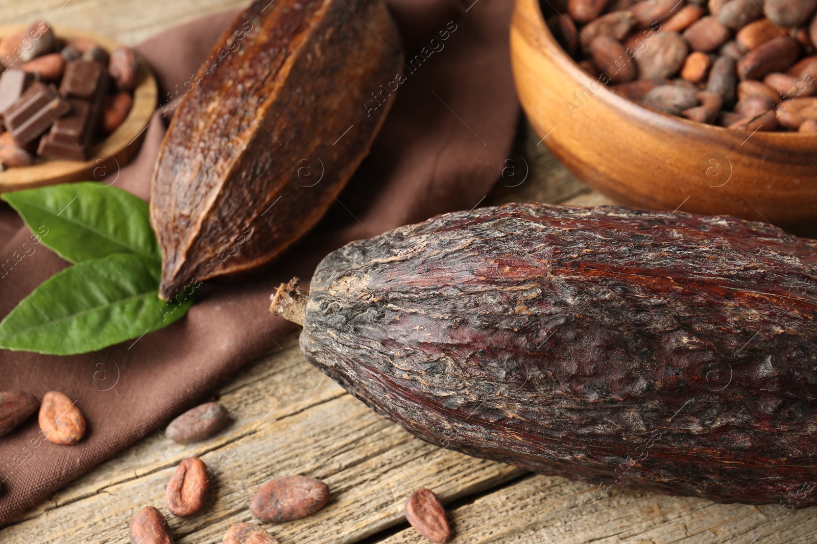 Photo of Cocoa pods and beans on wooden table, closeup
