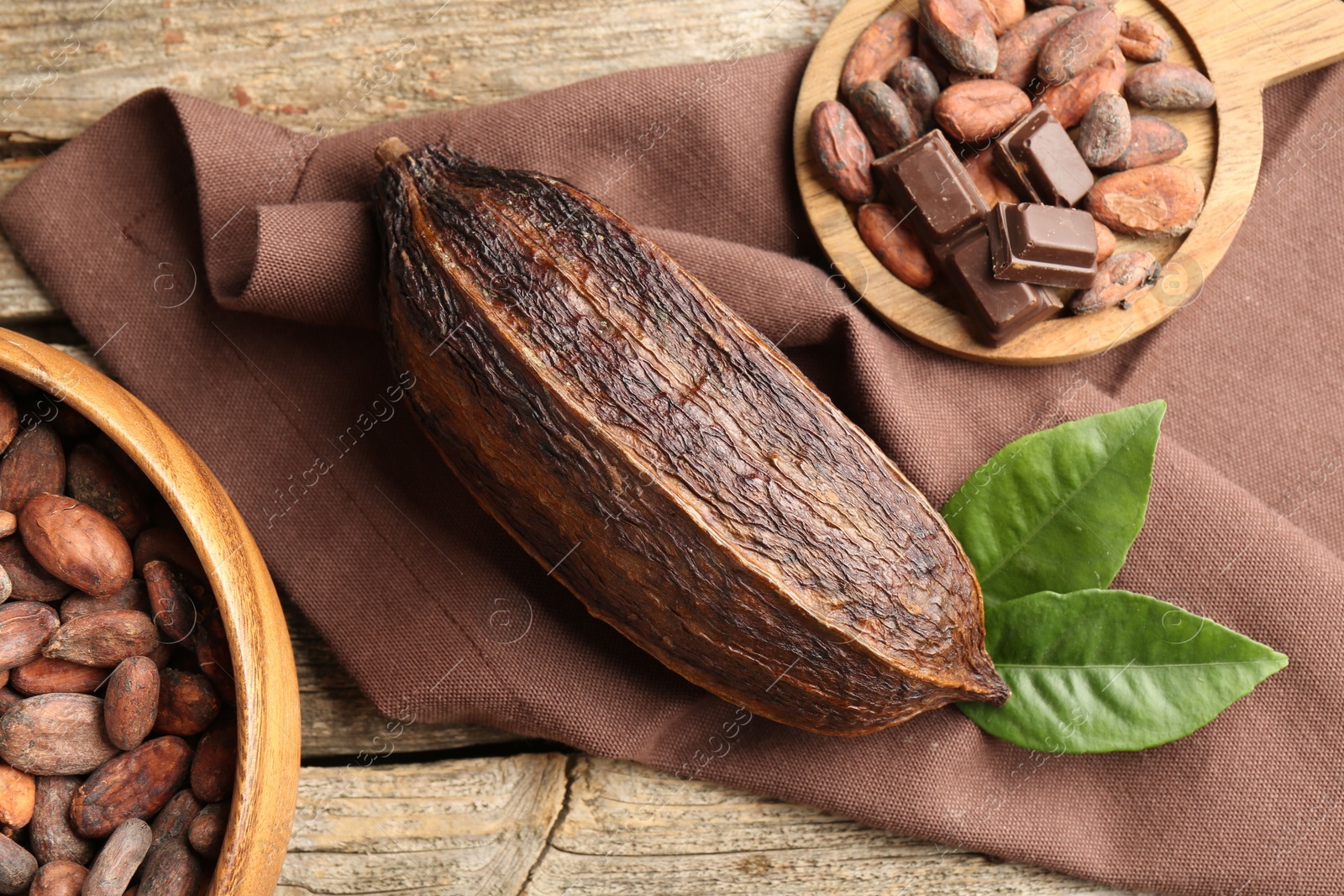 Photo of Cocoa pod and beans on wooden table, flat lay