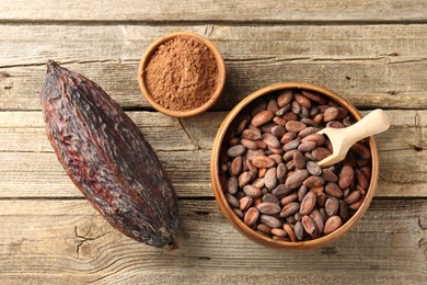 Cocoa pod, powder and beans on wooden table, flat lay