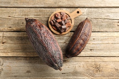 Photo of Cocoa pods and beans on wooden table, top view