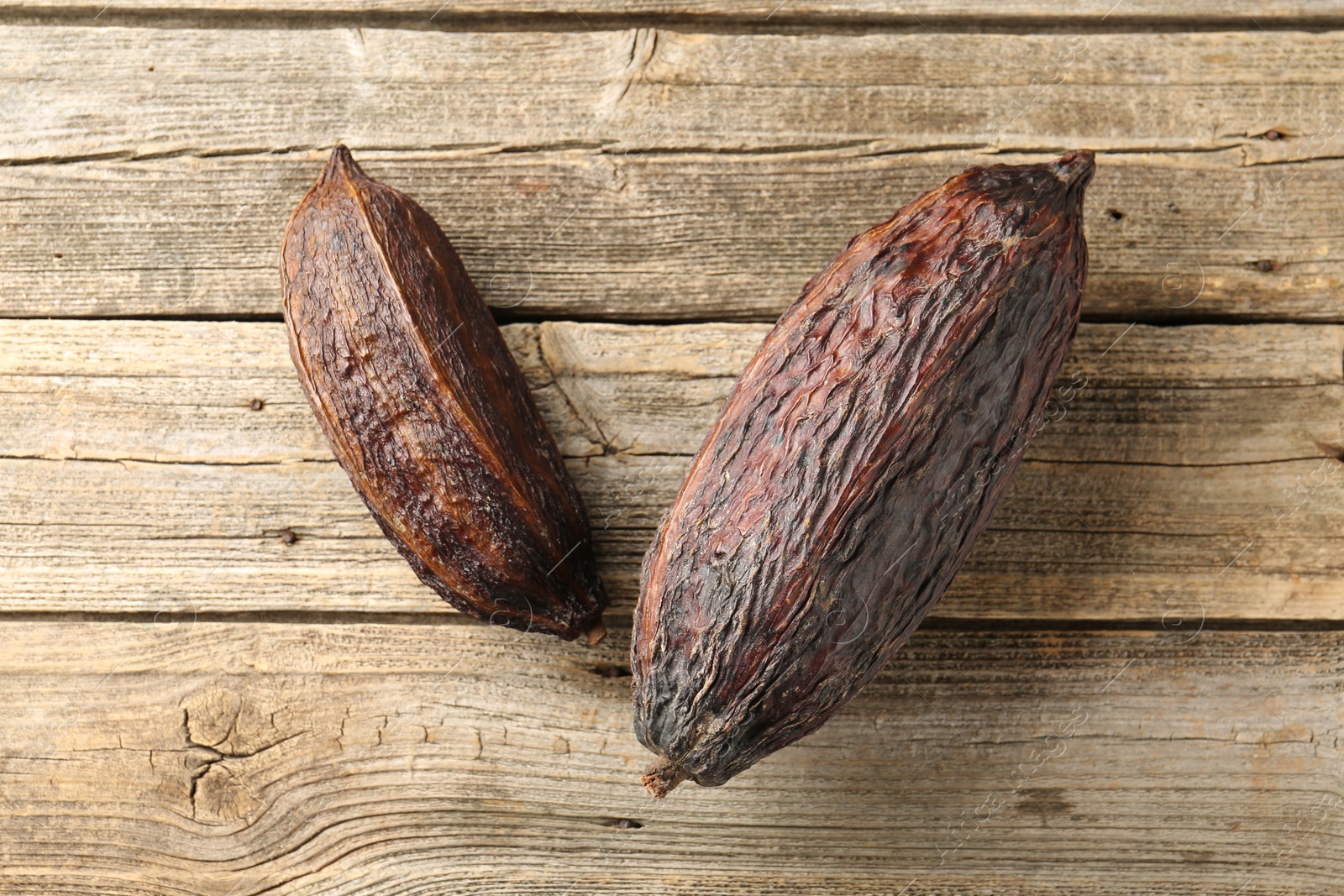 Photo of Cocoa pods on wooden table, top view