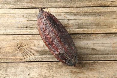 Photo of Cocoa pod on wooden table, top view