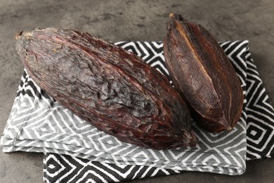 Natural cocoa pods on grey table, closeup