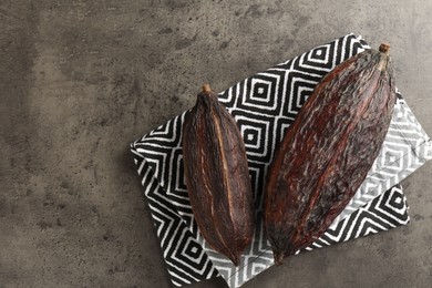 Cocoa pods on grey table, top view