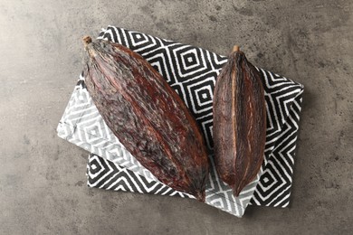 Cocoa pods on grey table, top view