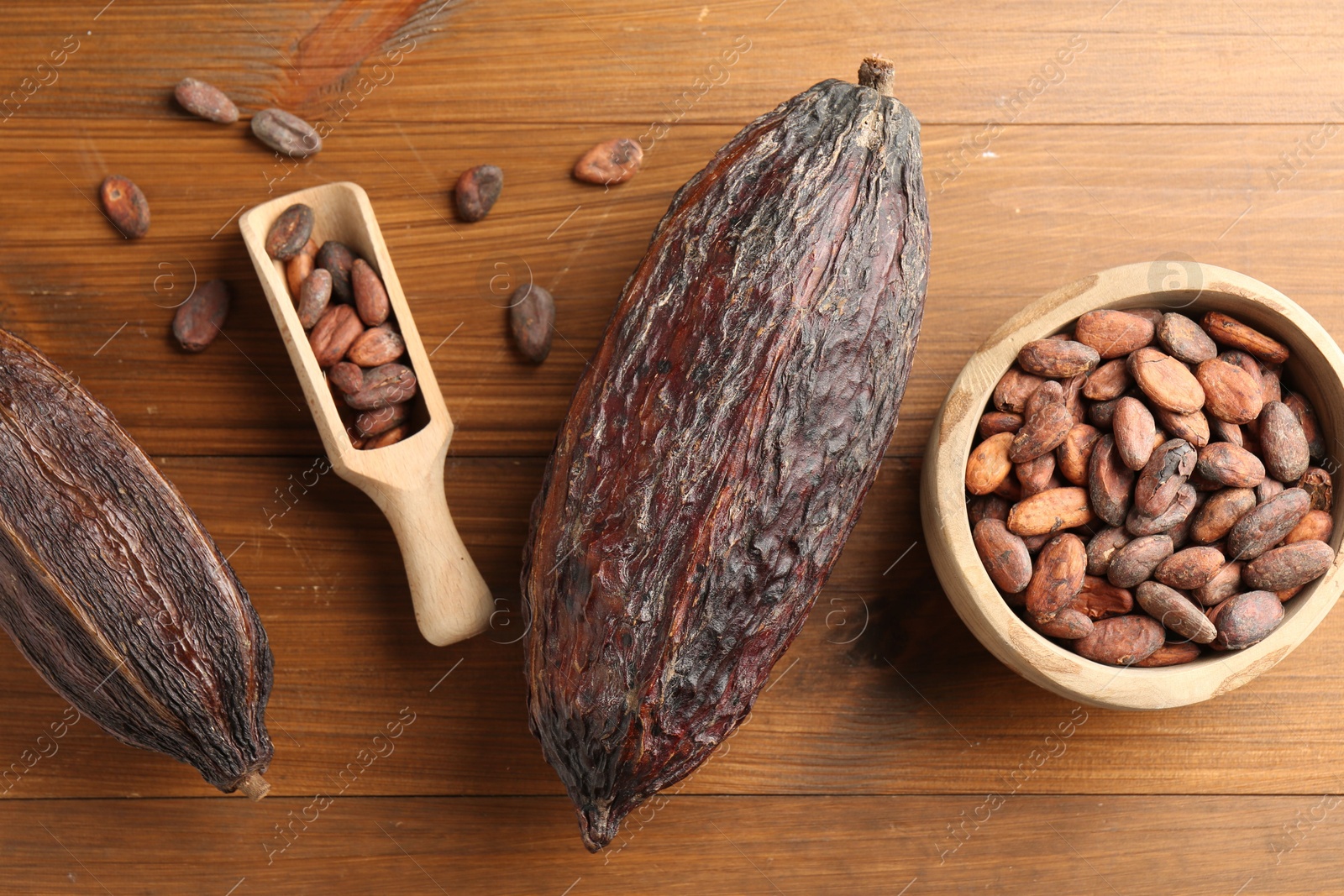 Photo of Cocoa pods and beans on wooden table, flat lay