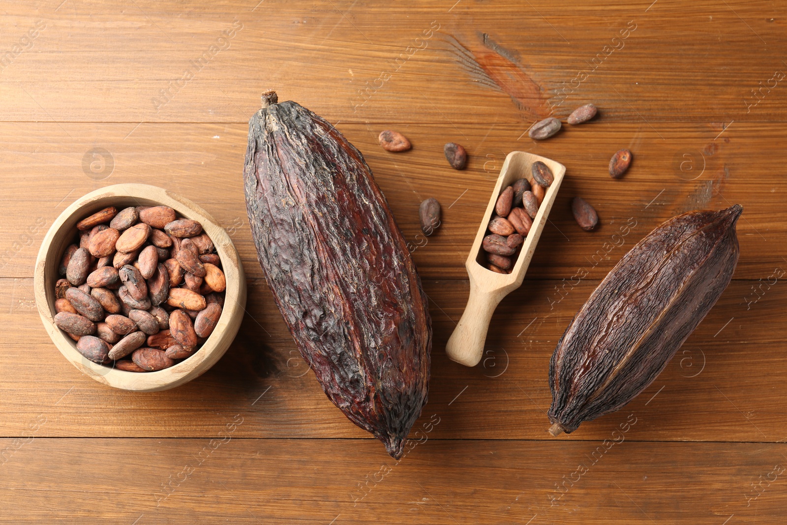 Photo of Cocoa pods and beans on wooden table, flat lay