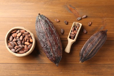 Photo of Cocoa pods and beans on wooden table, flat lay