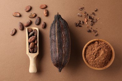 Cocoa pod, beans and powder on brown background, flat lay