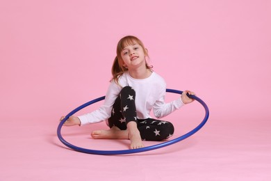 Photo of Cute little girl with hula hoop on pink background