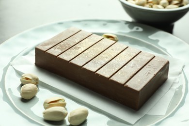 Tasty Dubai chocolate with pistachios and knafeh on table, closeup