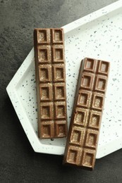 Photo of Tasty Dubai chocolate with pistachios and knafeh on grey textured table, top view