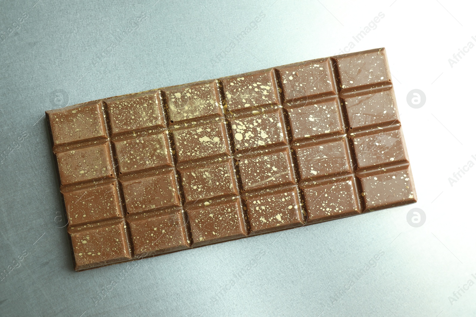 Photo of One tasty Dubai chocolate bar with pistachios and knafeh on grey table, top view