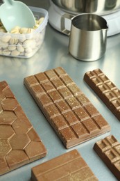 Photo of Different tasty Dubai chocolate bars with pistachios and knafeh on grey table