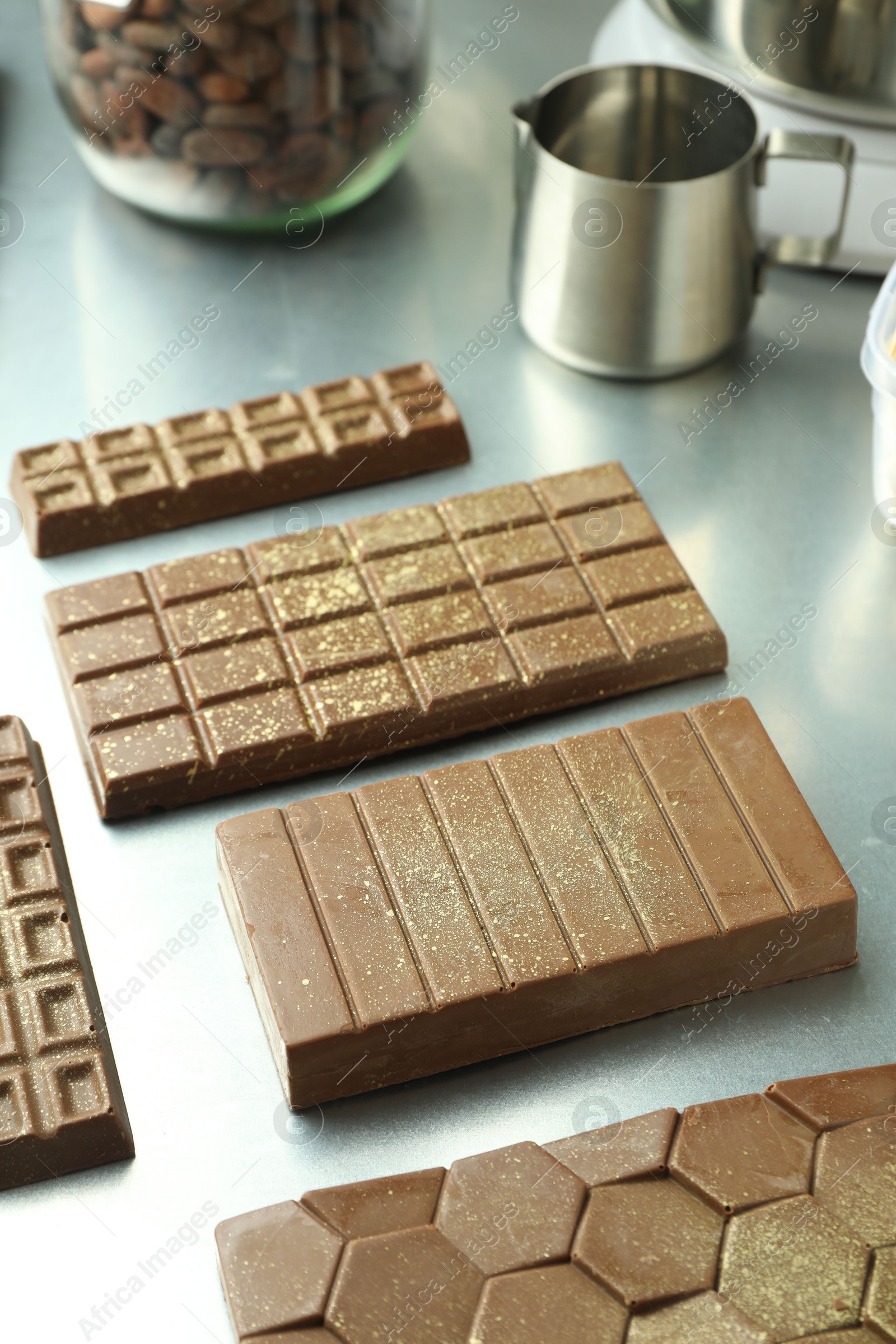 Photo of Different tasty Dubai chocolate bars with pistachios and knafeh on grey table