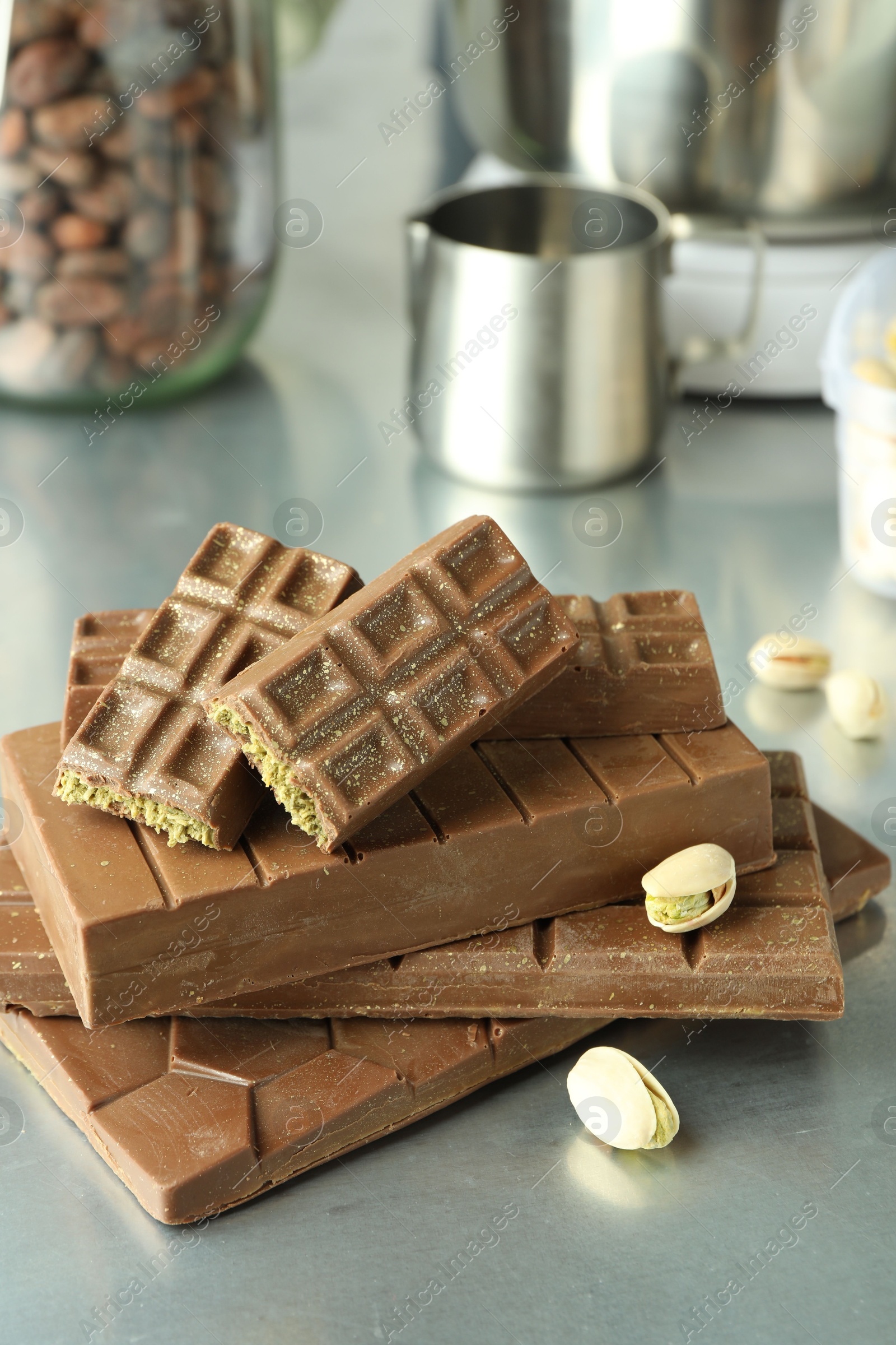 Photo of Stack of tasty Dubai chocolate bars with pistachios and knafeh on grey table