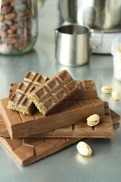 Photo of Stack of tasty Dubai chocolate bars with pistachios and knafeh on grey table