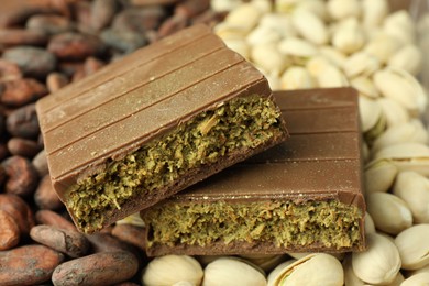 Photo of Pieces of tasty Dubai chocolate with knafeh, pistachios and cocoa beans, closeup