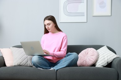 Photo of Young woman working on laptop at home